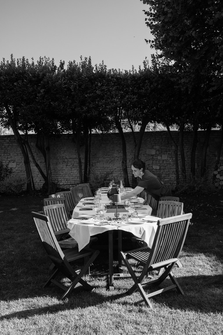 Table dressée dans un jardin, en noir et blanc, juste avant l'arrivée des convives