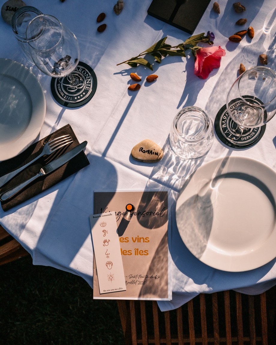 Table dressée vue de dessus avec le menu d'un voyage sensoriel et une boussole des sens